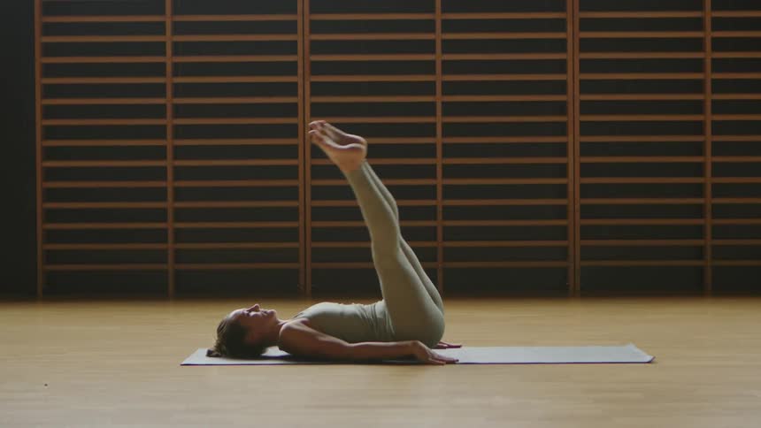 A woman is stretching on the floor in a room