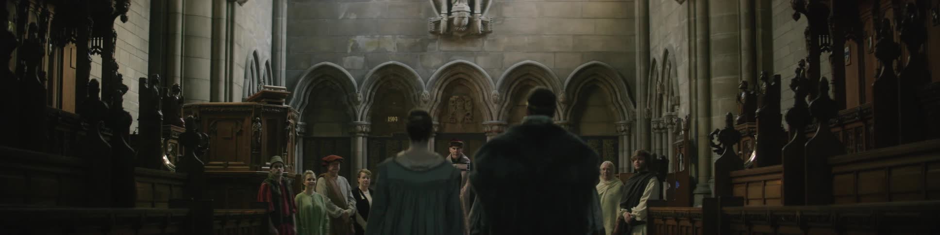A man and women walk over to a group of people in a church