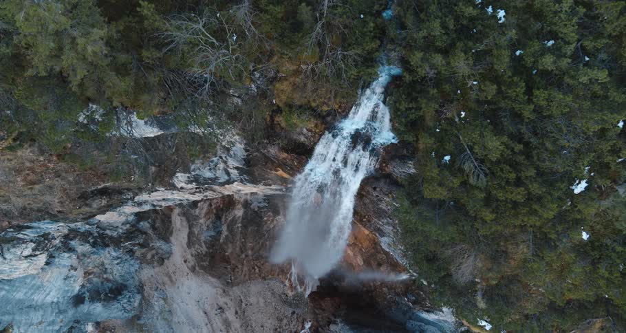 Zoom in of waterfall from a mountain during the day