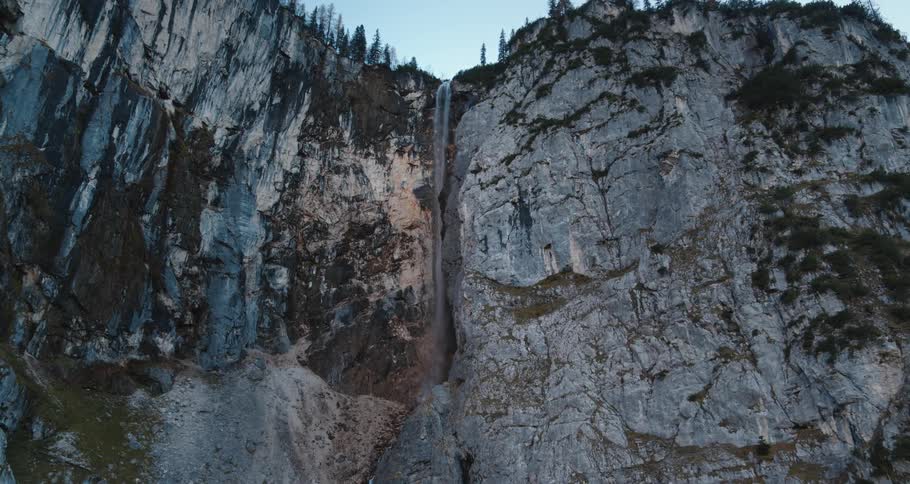 Small stream of water pouring down the side of a cliff in a canyon