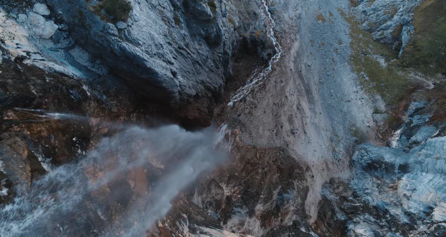 Waterfall in a canyon on the side of a mountain cliff
