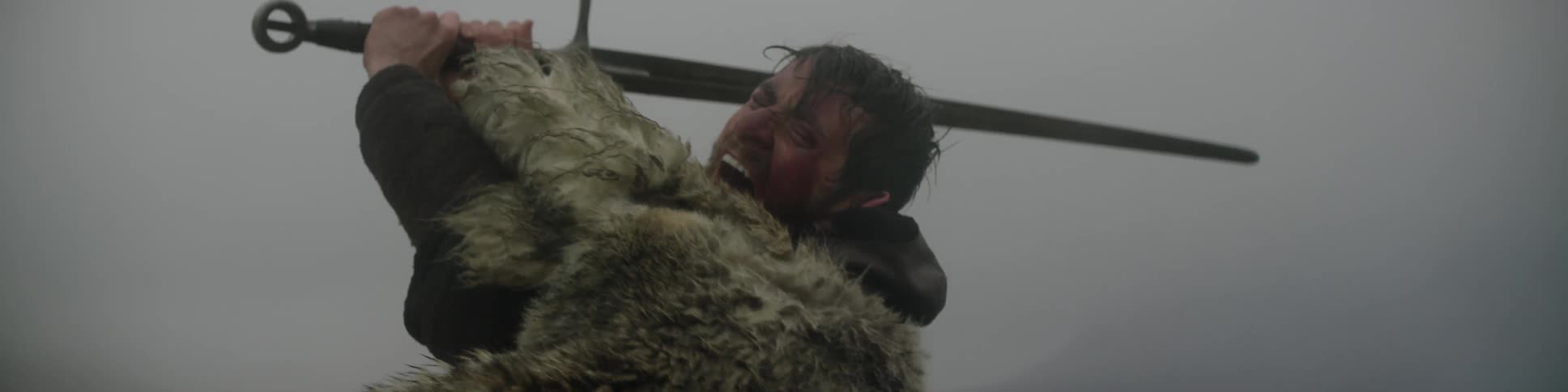 A man in a fur cloak swings a sword