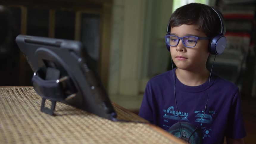 Child focusing on a tablet