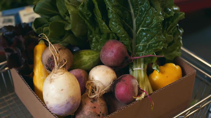 Box of fresh produce in a grocery store shopping cart