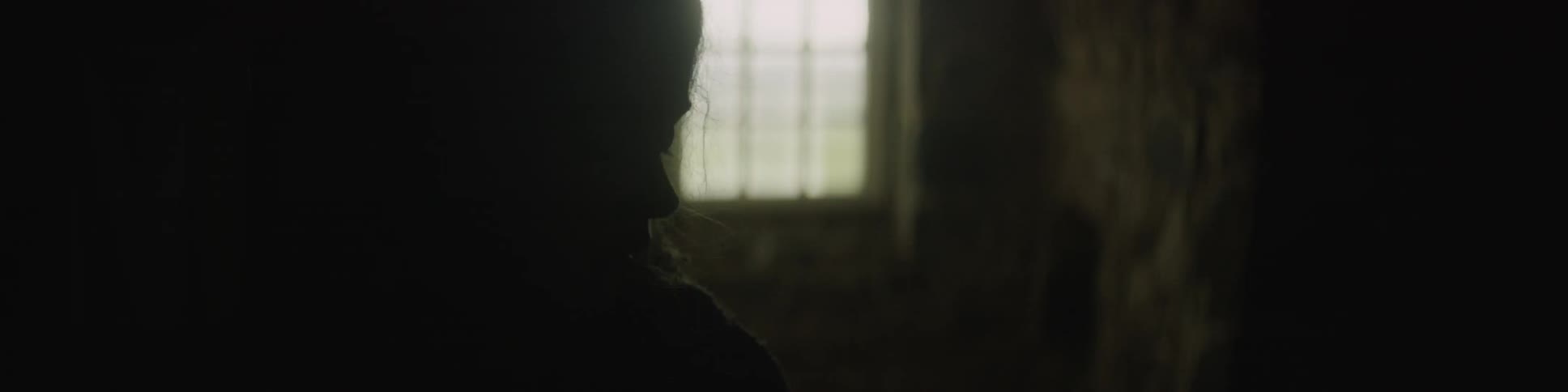 A woman sitting in a dark room