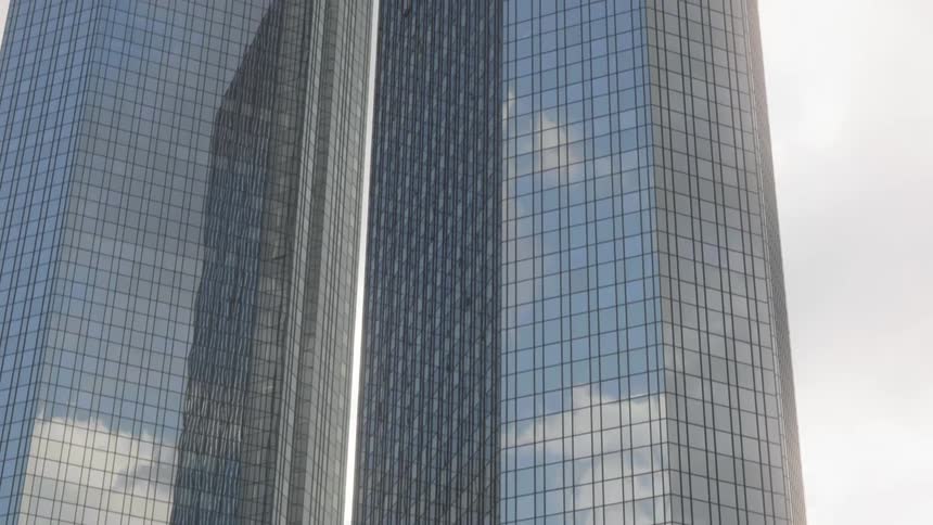 Tall city building reflecting the sky and the clouds