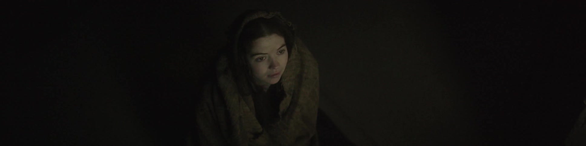 A woman with a shawl looks upward
