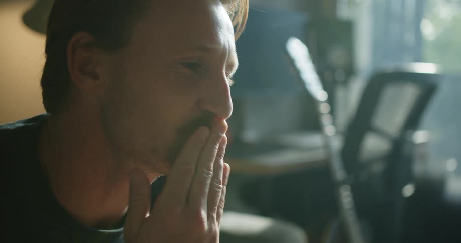 A man makes a kissing gesture using his hand and pressing it to his lips