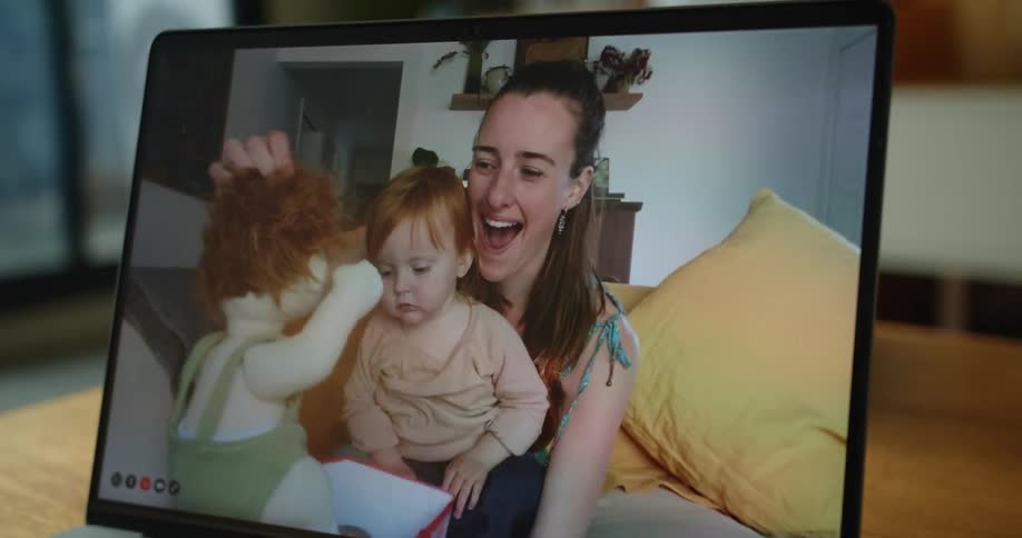 A woman and child open a present on a laptop screen