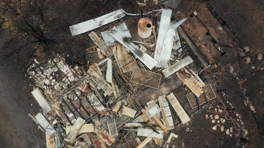 Shot over a destroyed industrial park with debris all over the dirt ground