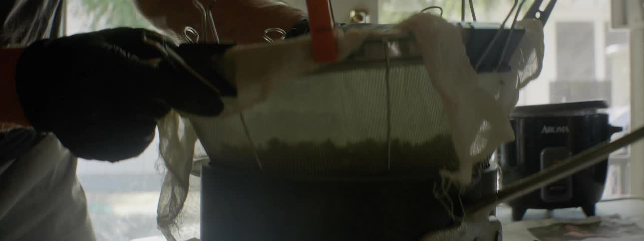 A strainer is pulled up from a pot with water streaming down