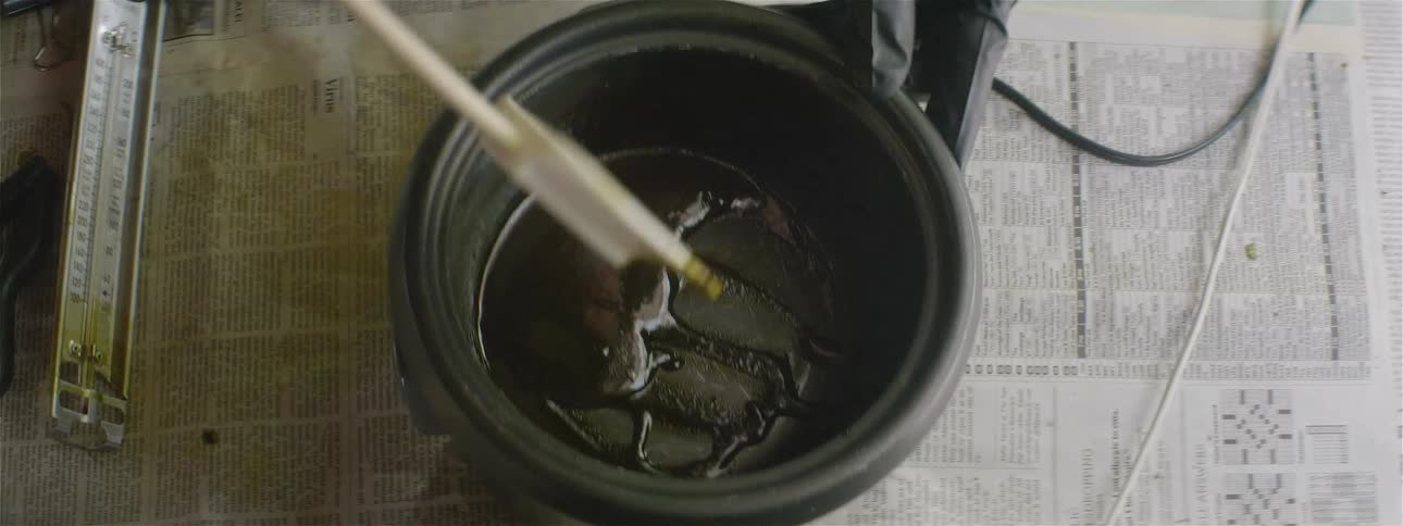 A person stirs a paste in a bowl using a spatula
