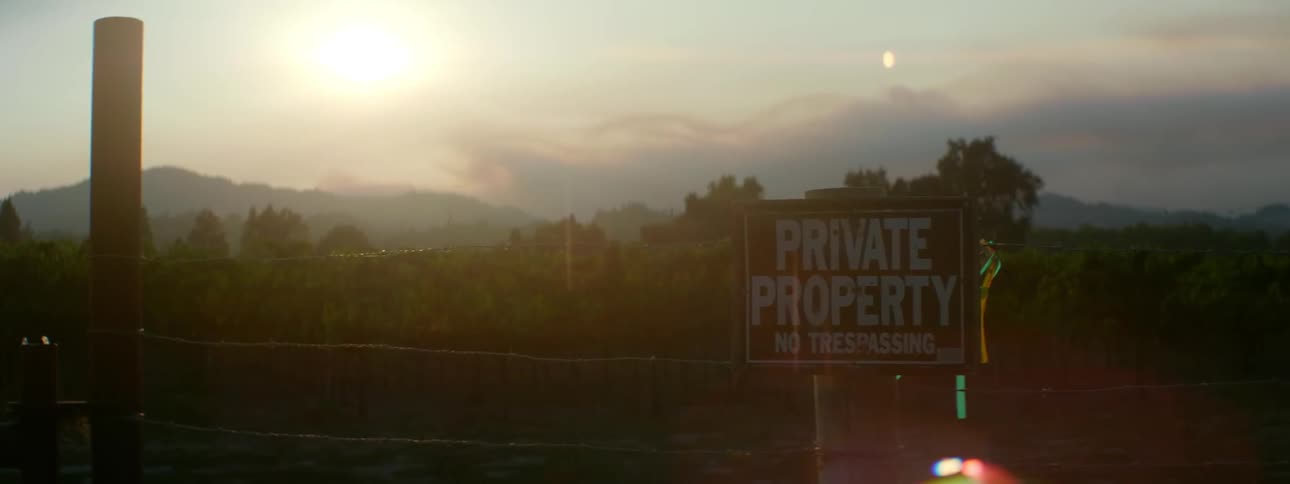 Fence with a no trespassing sign on a sunny day