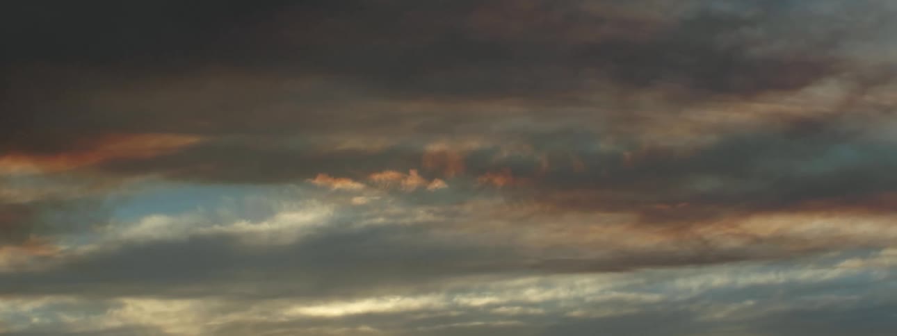 Cloudy sky and cloud formation with suns colors in the clouds