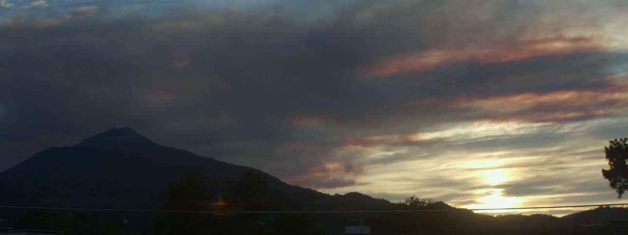 View of a mountain with sun going down behind it