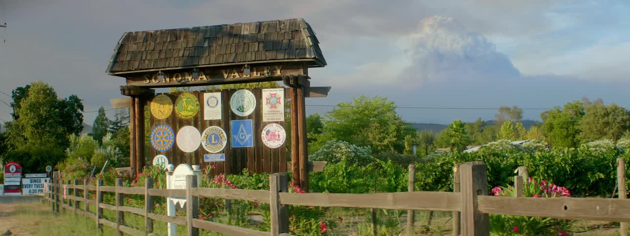Bulletin board with signs behind a fence in farmland country