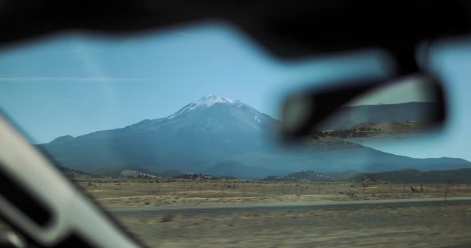 A car drives on a road near a mountain
