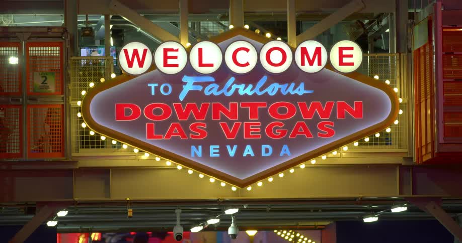 A flashing neon sign outside a building welcomes visitors to downtown las vegas