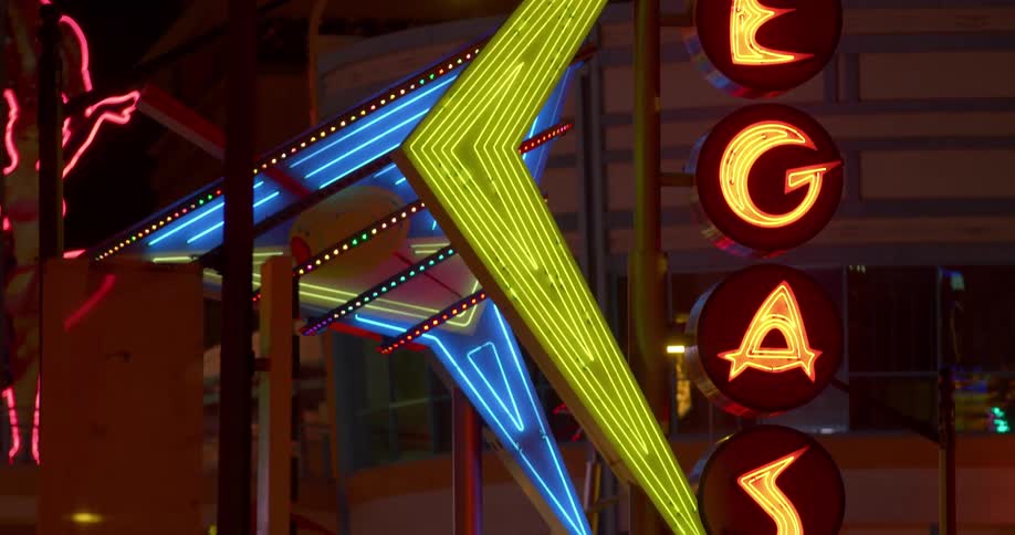 Blinking neon sign at night time with the word vegas flashing on and off