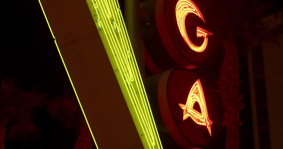 A red and yellow sign flashes at night in las vegas