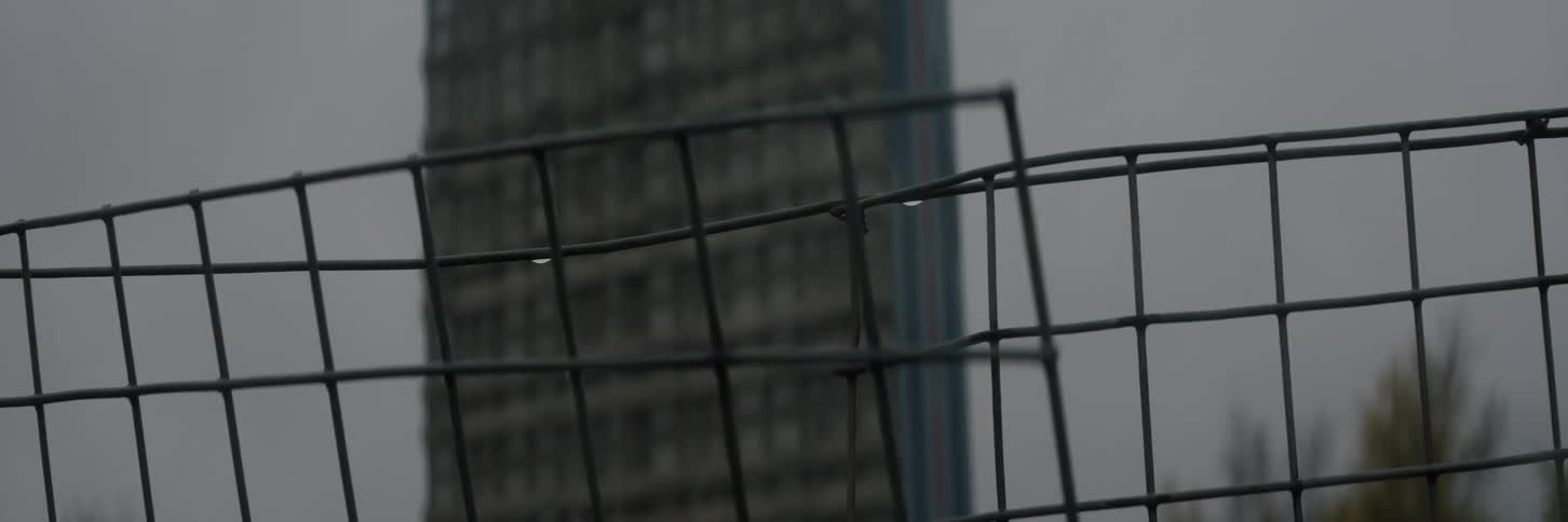 A footage of a high rise building and a wire fence