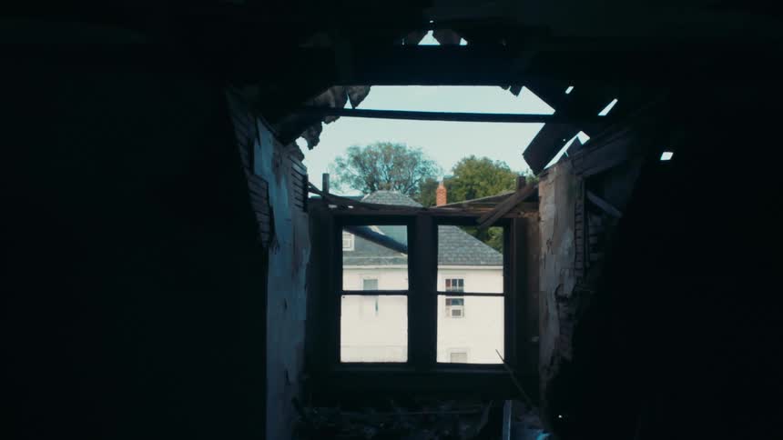 Flies buzzing around inside of an abandoned old building with a piece of ceiling missing