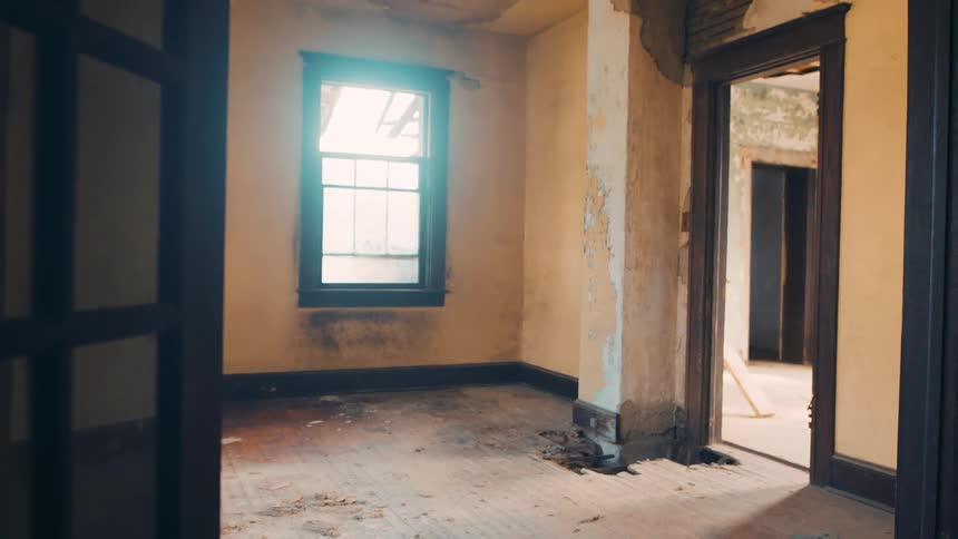 An abandoned house with damaged ceiling and chipped paint