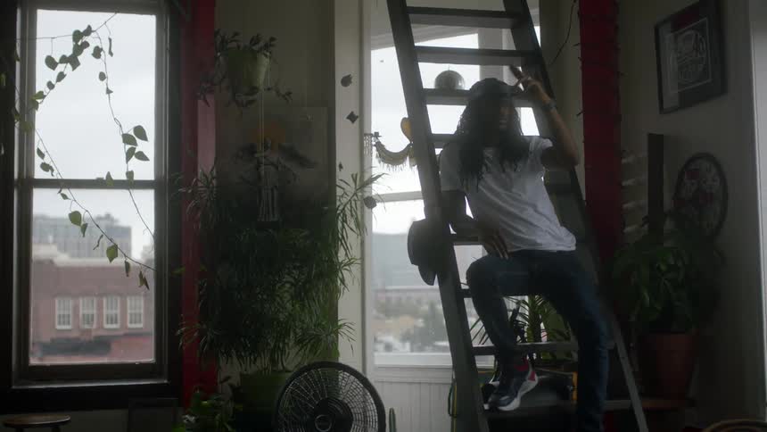Man sits on ladder wearing vr visor gesturing in building