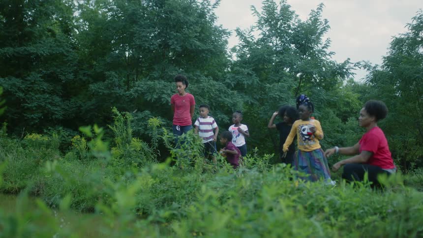 A group of children throwing rocks in a river