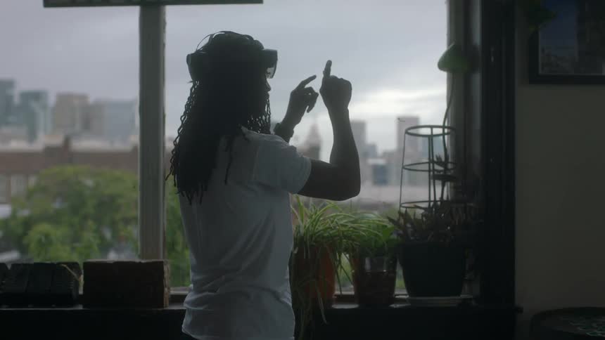A young man plays a virtual reality game at home