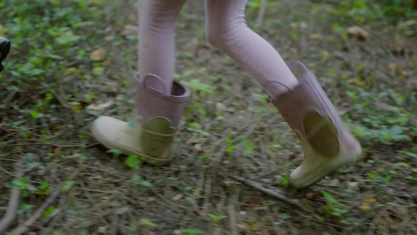 Three people walk outdoors in the grass