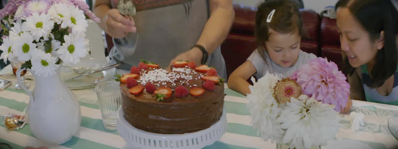 A woman prepares to a cut a cake
