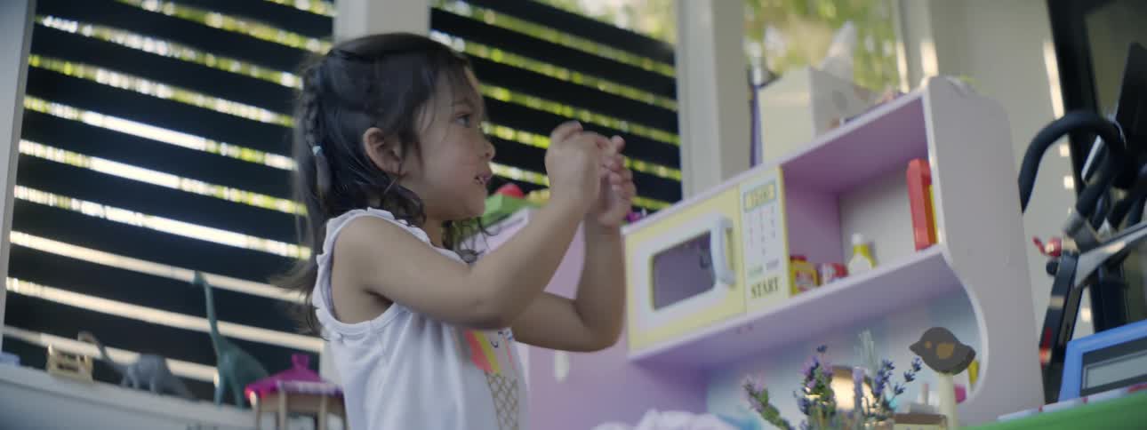 A little girl is playing and talking to a woman in a playroom