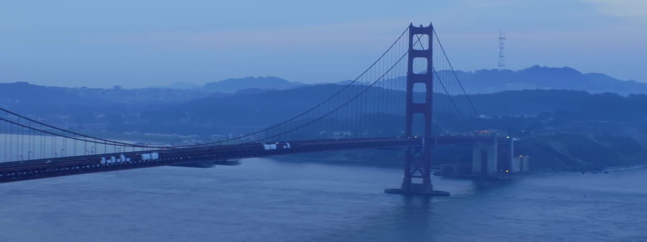 Traffic moves across the golden gate bridge on a foggy day