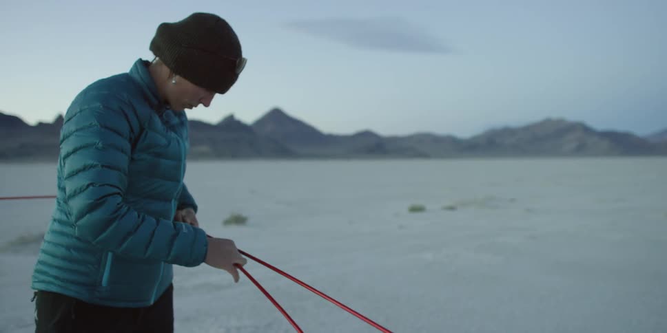 A woman erects a tent in the wilderness
