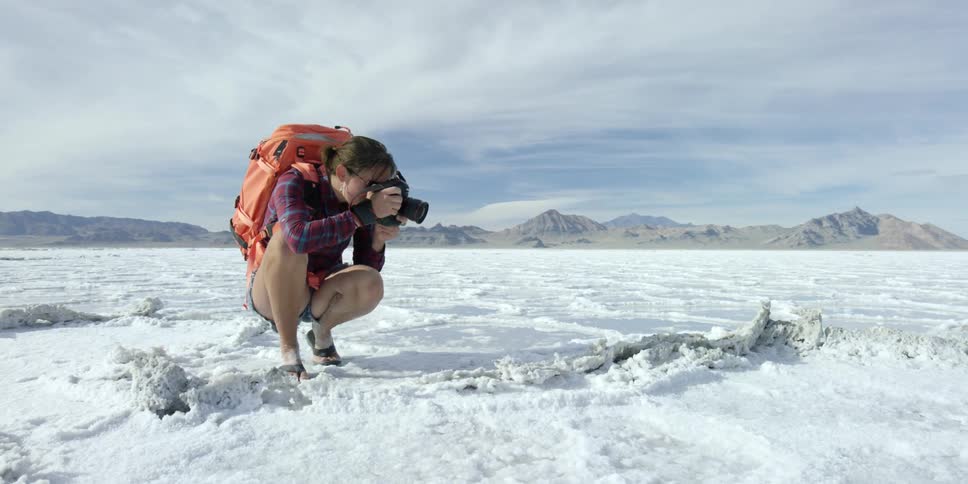 A woman photographing something in the snow