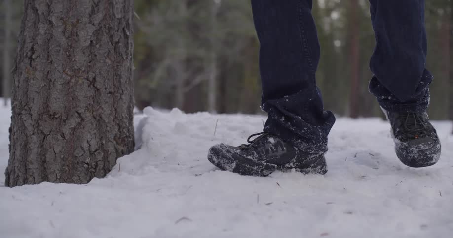 A person is walking across the snow with boots on