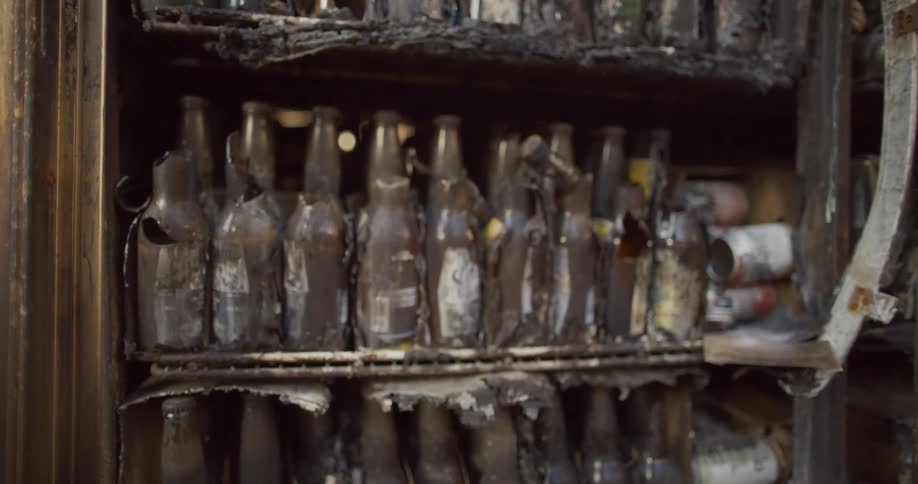 Broken glass bottle sit on shelf on ruined charged shelving