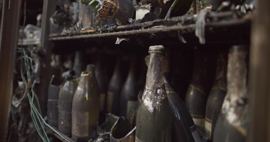 Shelves of dusty broken bottles of beer