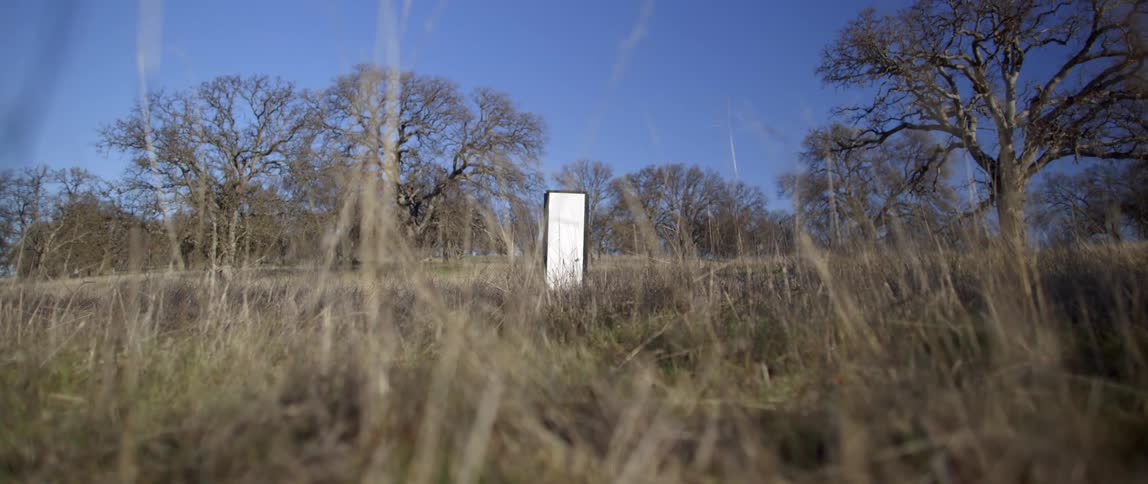 A large door shaped item is randomly placed in a field in the countryside