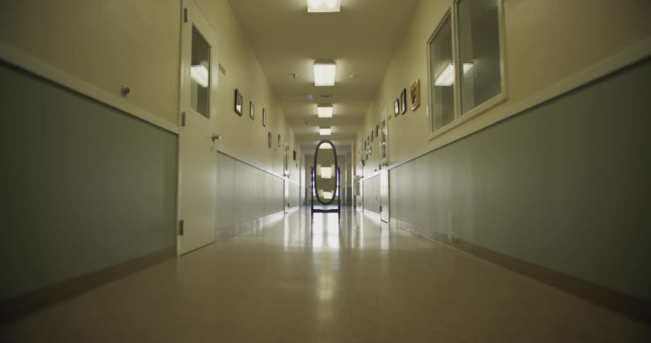 A hallway in a building that has doors and windows