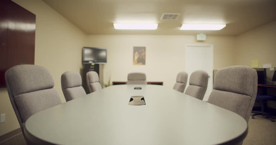 A conference room with gray chairs and gray topped table