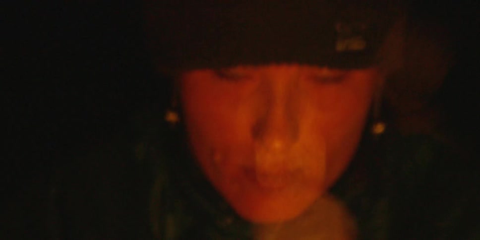 Close up of a woman as she looks at a fire