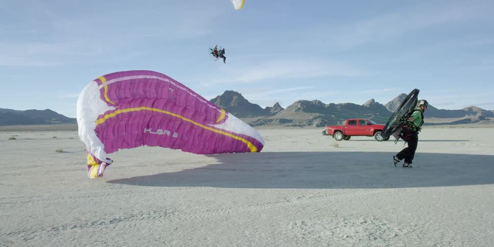 A man is getting a run to start paragliding