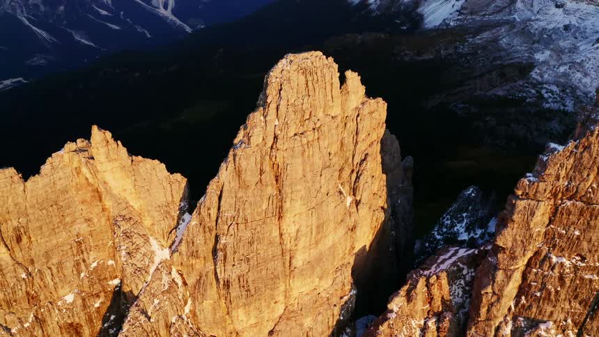 Sunshine brightens mountain side and peaks leaving valley in center dark