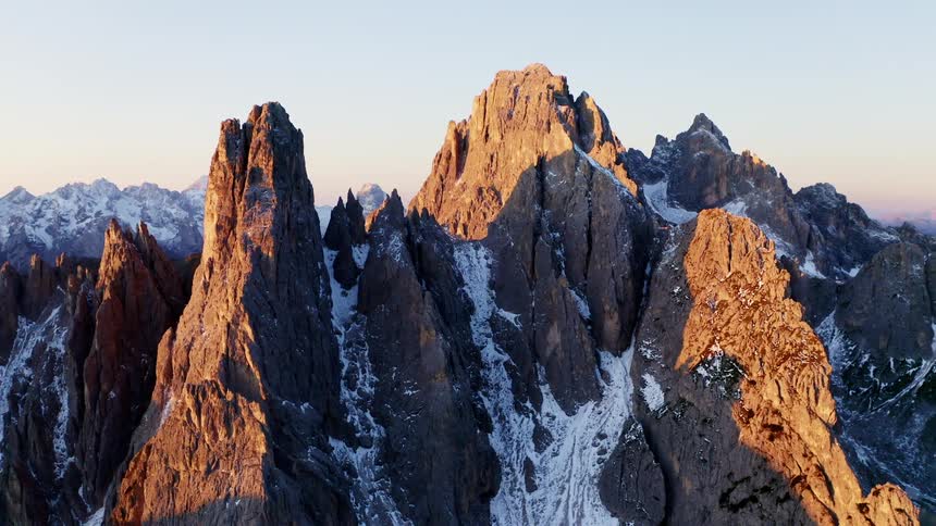 Mountain peaks covered in snow with the sun shining over them