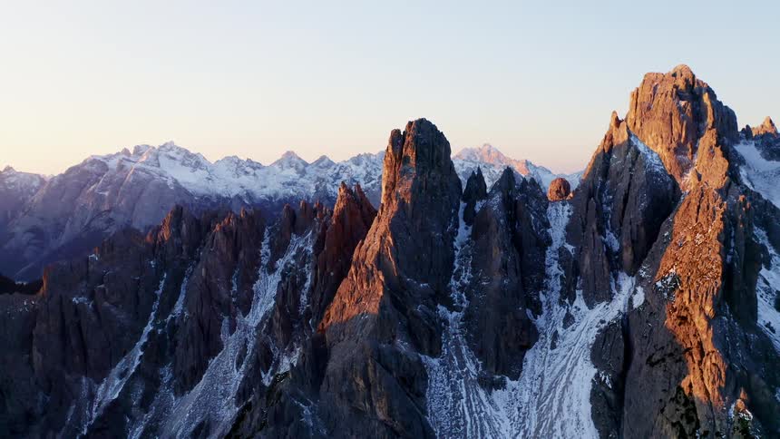 Aerial view of snowy rugged mountains at dusk