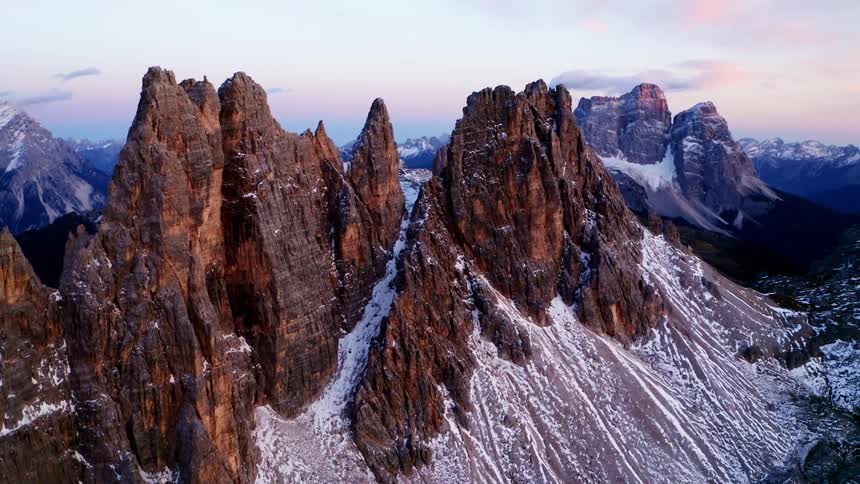 Aerial view of the snowy rugged mountains at dusk