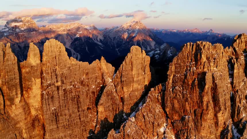 An aerial view of mountains with snow caps during daylight