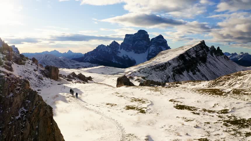 Three people trekking on the snow in the mountains